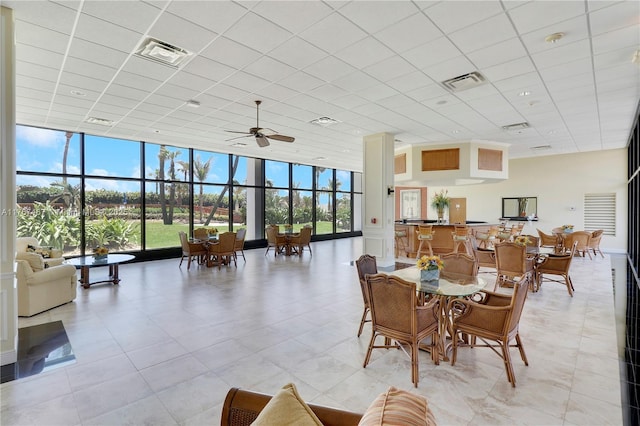 10410 S Ocean Dr Unit 504, Jensen Beach, FL 34957 - dining room with a drop ceiling, floor to ceiling windows, a high ceiling, a ceiling fan, and light tile patterned floors