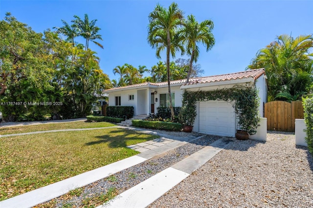 view of front of home with fence, driveway, stucco siding, a garage, and a tile roof