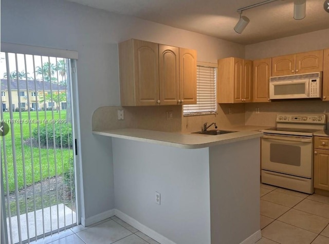 kitchen with white appliances, light tile patterned floors, light brown cabinets, a sink, and light countertops
