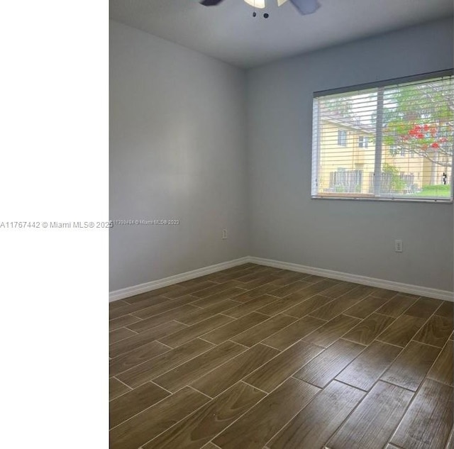 spare room with baseboards, ceiling fan, and wood tiled floor