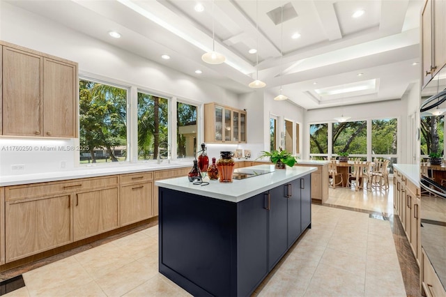665 Leucadendra Dr, Coral Gables, FL 33156 - kitchen featuring light tile patterned flooring, light countertops, a kitchen island, a raised ceiling, and light brown cabinets