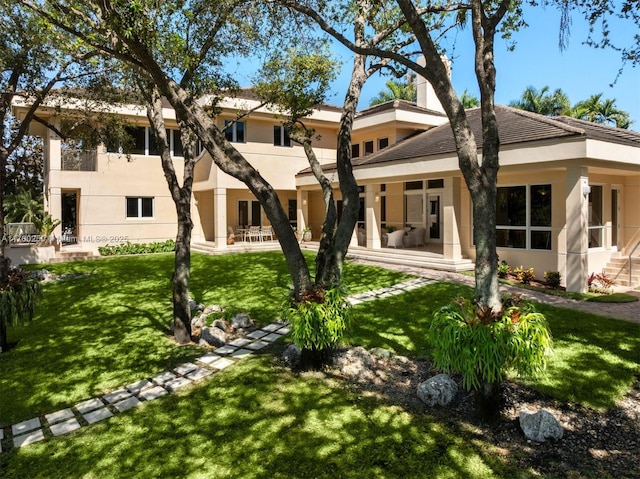 665 Leucadendra Dr, Coral Gables, FL 33156 - rear view of property featuring stucco siding and a lawn