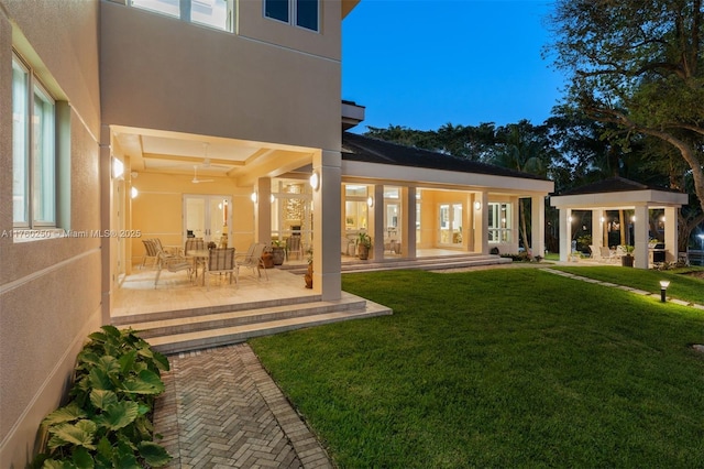 665 Leucadendra Dr, Coral Gables, FL 33156 - rear view of house featuring stucco siding, a yard, and a patio area