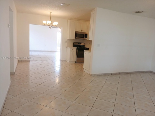 6464 Johnson St, Hollywood, FL 33024 - kitchen featuring a chandelier, stainless steel appliances, light tile patterned floors, white cabinetry, and light countertops