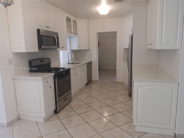 6464 Johnson St, Hollywood, FL 33024 - kitchen featuring white cabinetry, light tile patterned flooring, appliances with stainless steel finishes, and a sink