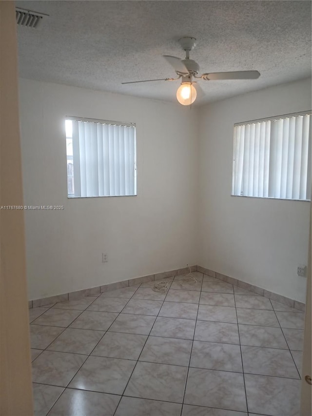 6464 Johnson St, Hollywood, FL 33024 - spare room featuring a textured ceiling, a healthy amount of sunlight, a ceiling fan, and visible vents