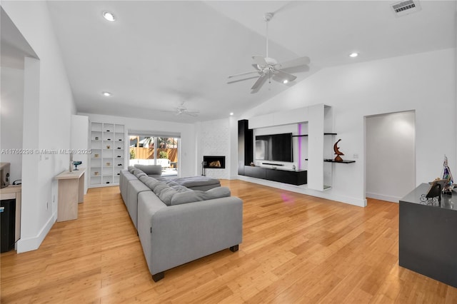 8951 SW 160th St, Palmetto Bay, FL 33157 - living area with visible vents, light wood-style flooring, a large fireplace, lofted ceiling, and ceiling fan