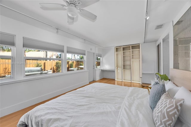 8951 SW 160th St, Palmetto Bay, FL 33157 - bedroom featuring a ceiling fan, wood finished floors, visible vents, baseboards, and rail lighting