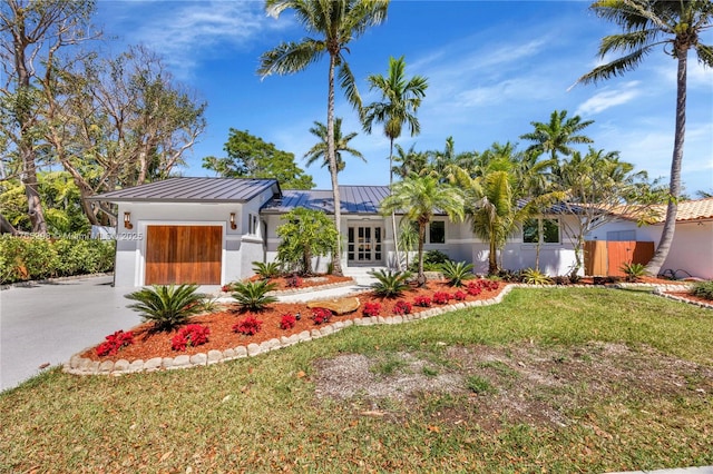 8951 SW 160th St, Palmetto Bay, FL 33157 - view of front facade featuring a front yard, driveway, a standing seam roof, an attached garage, and metal roof
