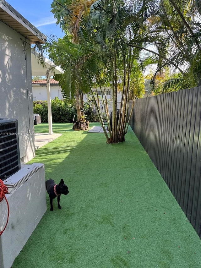 view of yard with cooling unit and a fenced backyard