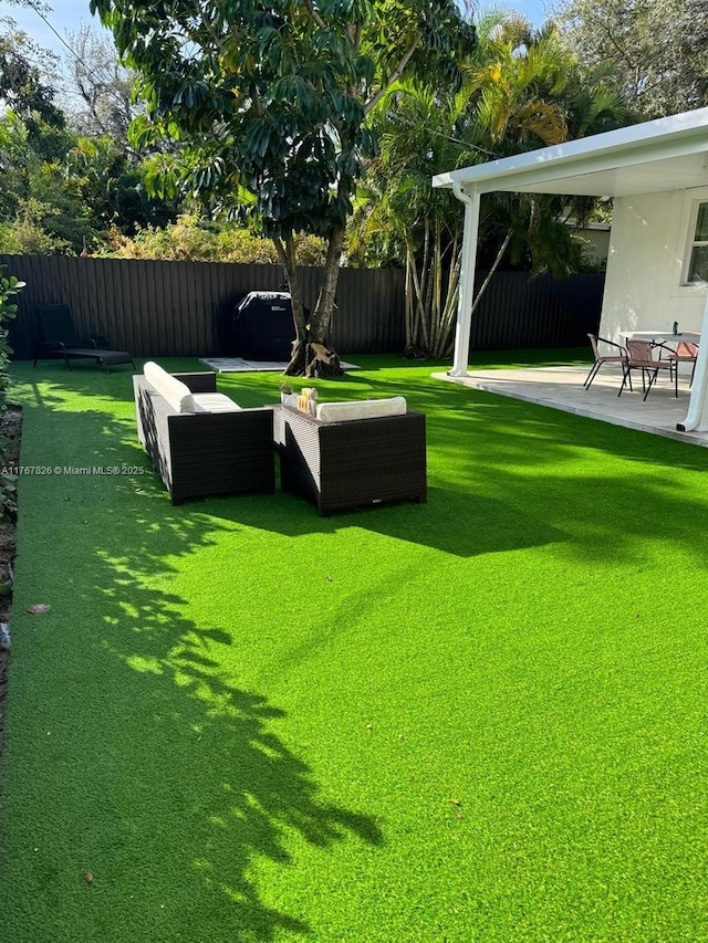 view of yard featuring outdoor lounge area, a fenced backyard, and a patio