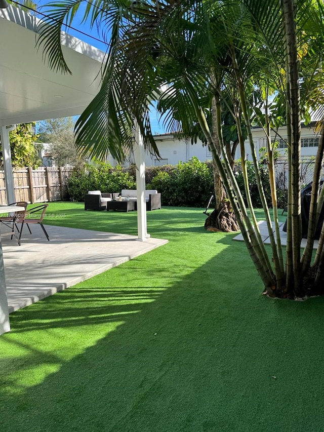 view of yard featuring a patio, an outdoor hangout area, and fence
