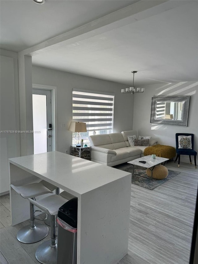 kitchen with a kitchen island, a notable chandelier, decorative light fixtures, and light wood-style floors