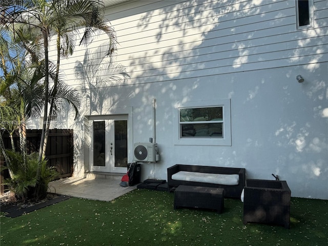 rear view of house with french doors, stucco siding, fence, ac unit, and a yard