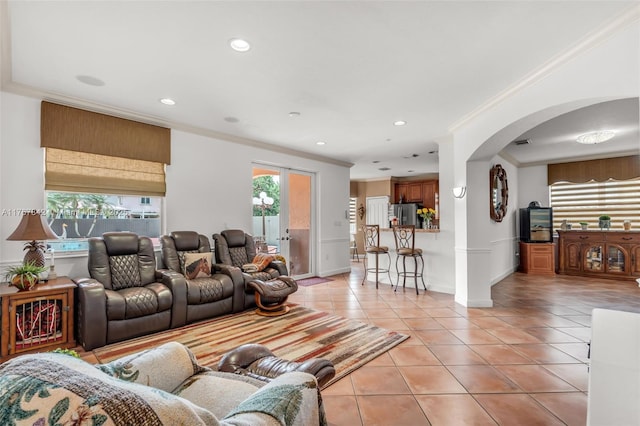 living room with light tile patterned floors, arched walkways, recessed lighting, and crown molding