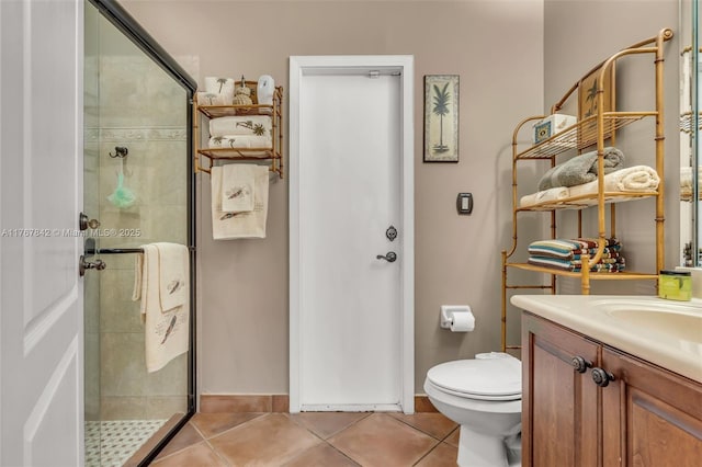 bathroom with tile patterned flooring, a shower stall, and vanity