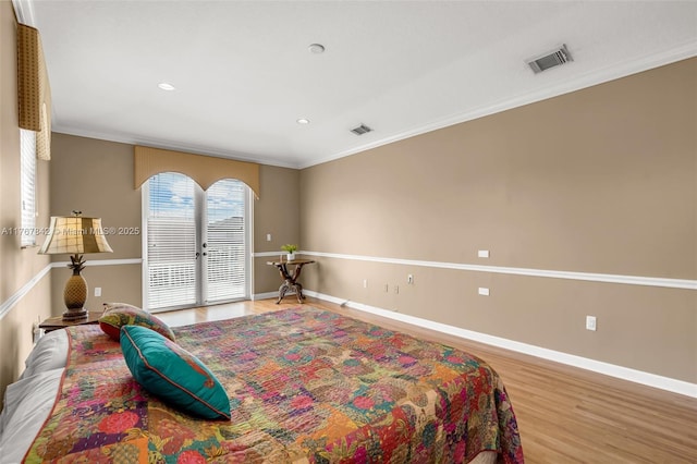 bedroom featuring baseboards, visible vents, ornamental molding, access to exterior, and light wood-type flooring