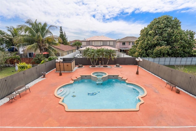 view of swimming pool with a patio area, a pool with connected hot tub, and a fenced backyard