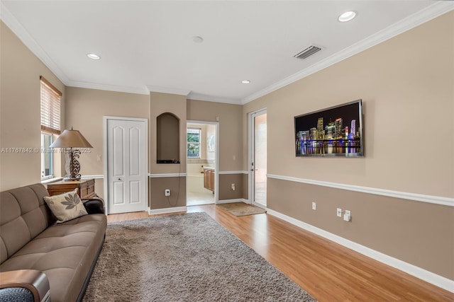 living room featuring light wood-style flooring, baseboards, visible vents, and a wealth of natural light