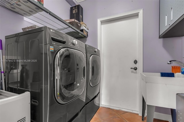 clothes washing area with tile patterned floors, independent washer and dryer, and a sink
