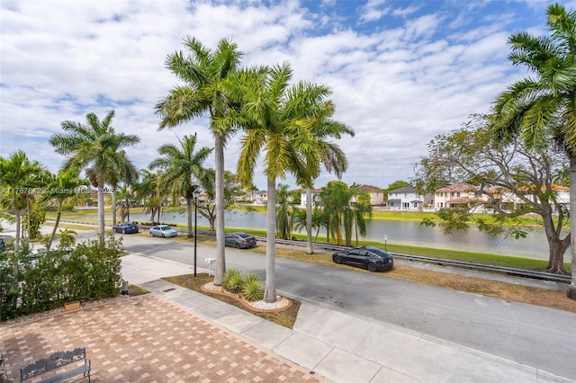 view of road with sidewalks and a water view