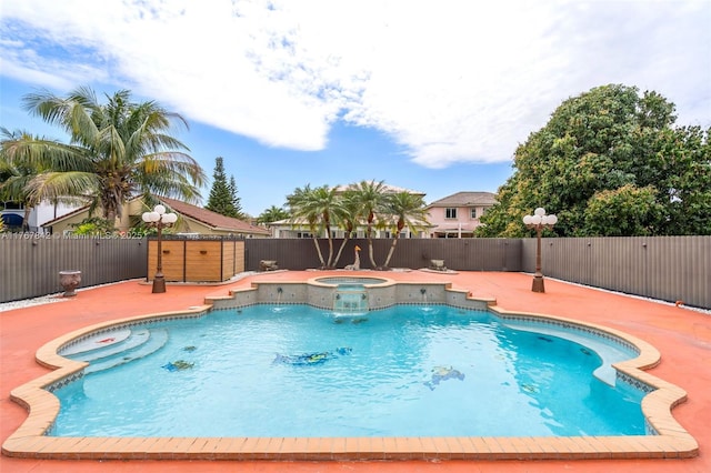 view of swimming pool featuring a fenced backyard, a pool with connected hot tub, and a patio