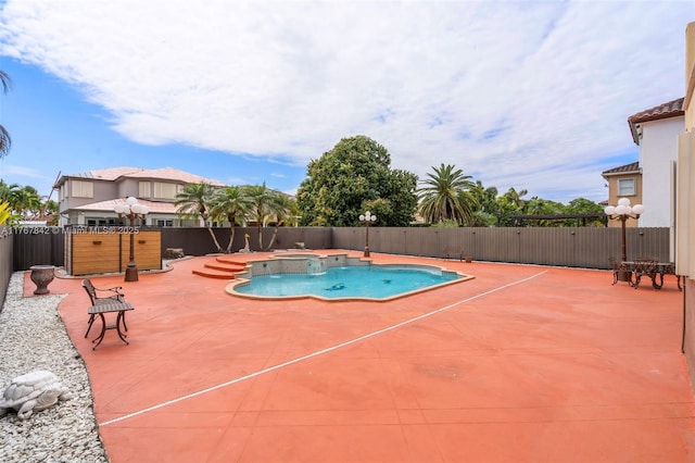 view of swimming pool with a pool with connected hot tub, a patio, and fence