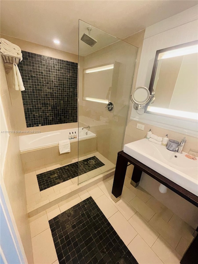 bathroom featuring tile patterned flooring, a tub, and tiled shower