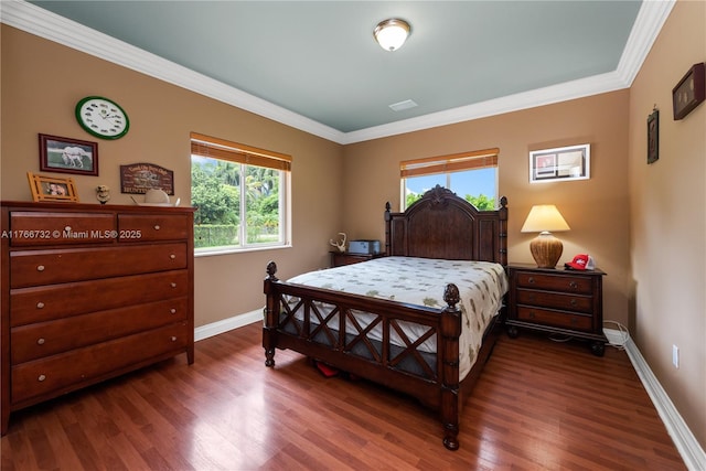bedroom featuring baseboards, wood finished floors, and ornamental molding