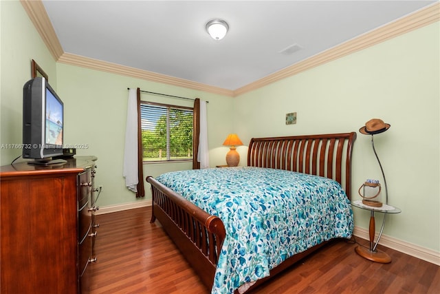bedroom with baseboards, wood finished floors, and crown molding