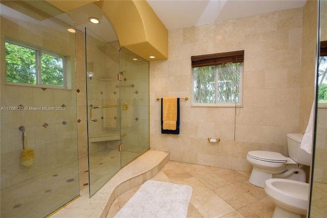 bathroom featuring tile walls, toilet, a bidet, and walk in shower