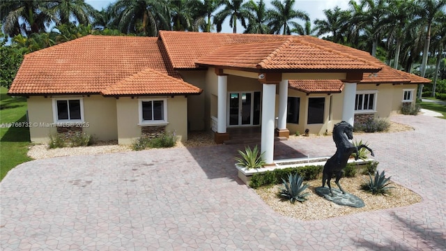 mediterranean / spanish home with stucco siding and a tile roof