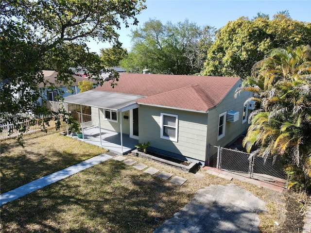 bungalow-style house with fence private yard, roof with shingles, a front yard, a patio area, and a gate