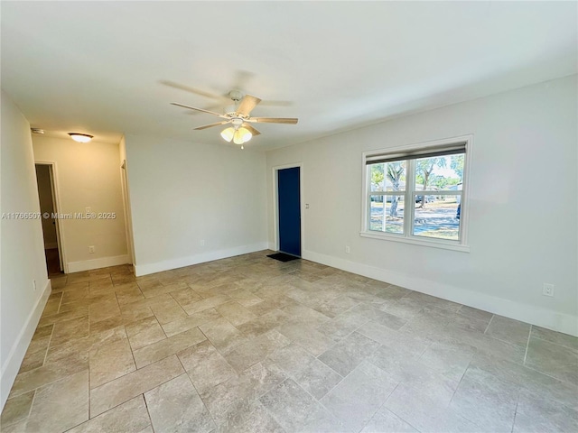 empty room featuring baseboards and ceiling fan