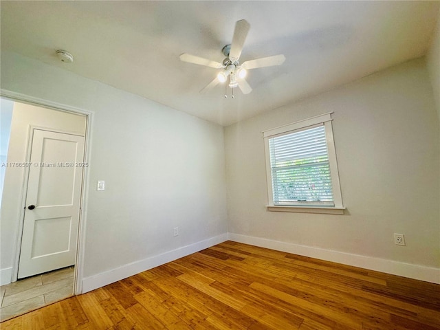 spare room featuring hardwood / wood-style flooring, baseboards, and ceiling fan