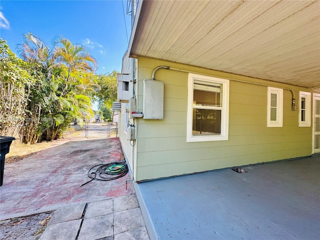 view of side of home featuring a patio and a gate