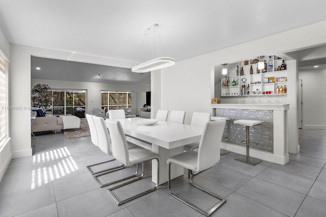 517 Misty Oaks Dr, Pompano Beach, FL 33069 - dining room with a bar, light tile patterned flooring, and baseboards