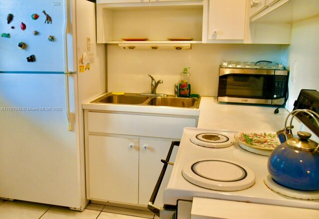 2910 Point E Dr Unit M414, Aventura, FL 33160 - kitchen featuring white appliances, light countertops, a sink, white cabinetry, and light tile patterned floors
