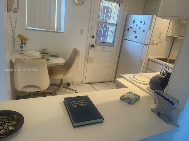 kitchen featuring light tile patterned floors, light countertops, and freestanding refrigerator