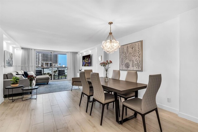 1904 S Ocean Dr Unit 801, Hallandale Beach, FL 33009 - dining space with floor to ceiling windows, a notable chandelier, light wood-style flooring, and baseboards