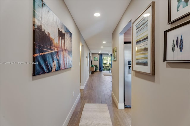 corridor with recessed lighting, baseboards, and wood finished floors