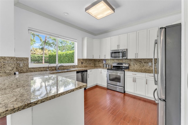 16831 SW 6th St, Pembroke Pines, FL 33027 - kitchen with stainless steel appliances, crown molding, light stone countertops, a sink, and white cabinetry