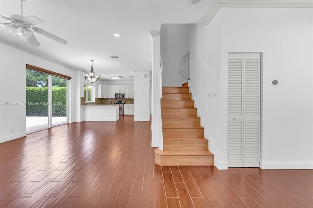 16831 SW 6th St, Pembroke Pines, FL 33027 - unfurnished living room featuring ceiling fan, a chandelier, stairway, dark wood-style floors, and crown molding