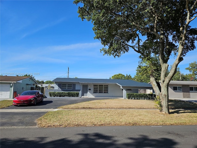 ranch-style house with aphalt driveway and a front lawn