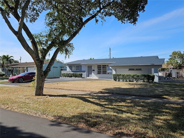 ranch-style house with a front yard and stucco siding