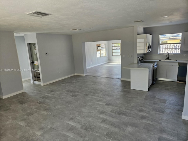 kitchen featuring a sink, dishwasher, white cabinetry, and range with electric cooktop