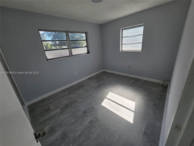 spare room with baseboards