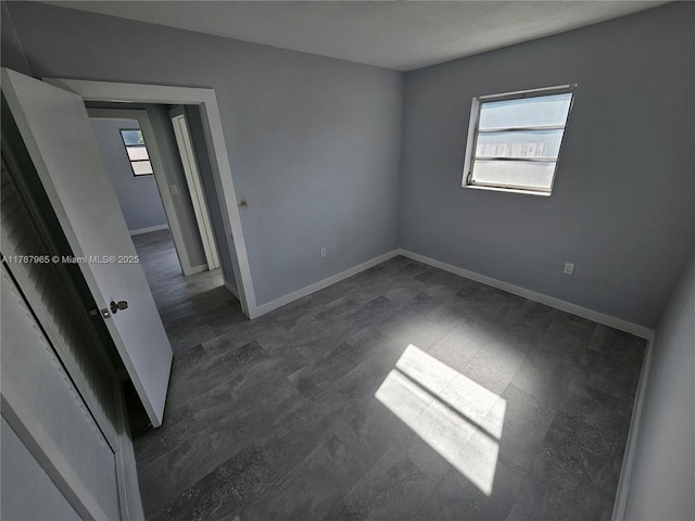 unfurnished bedroom featuring dark wood finished floors and baseboards