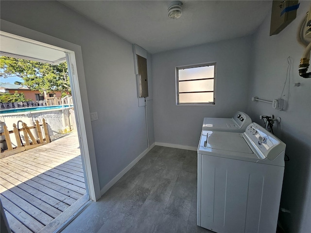 clothes washing area with washer and clothes dryer, laundry area, baseboards, and dark wood-style floors