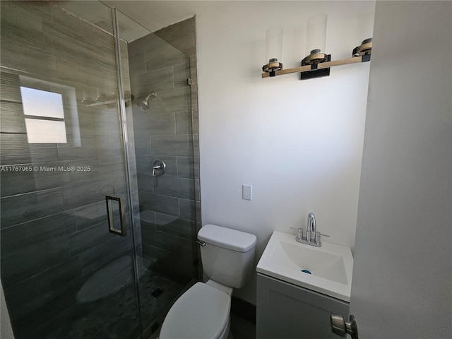 bathroom with toilet, a stall shower, and vanity